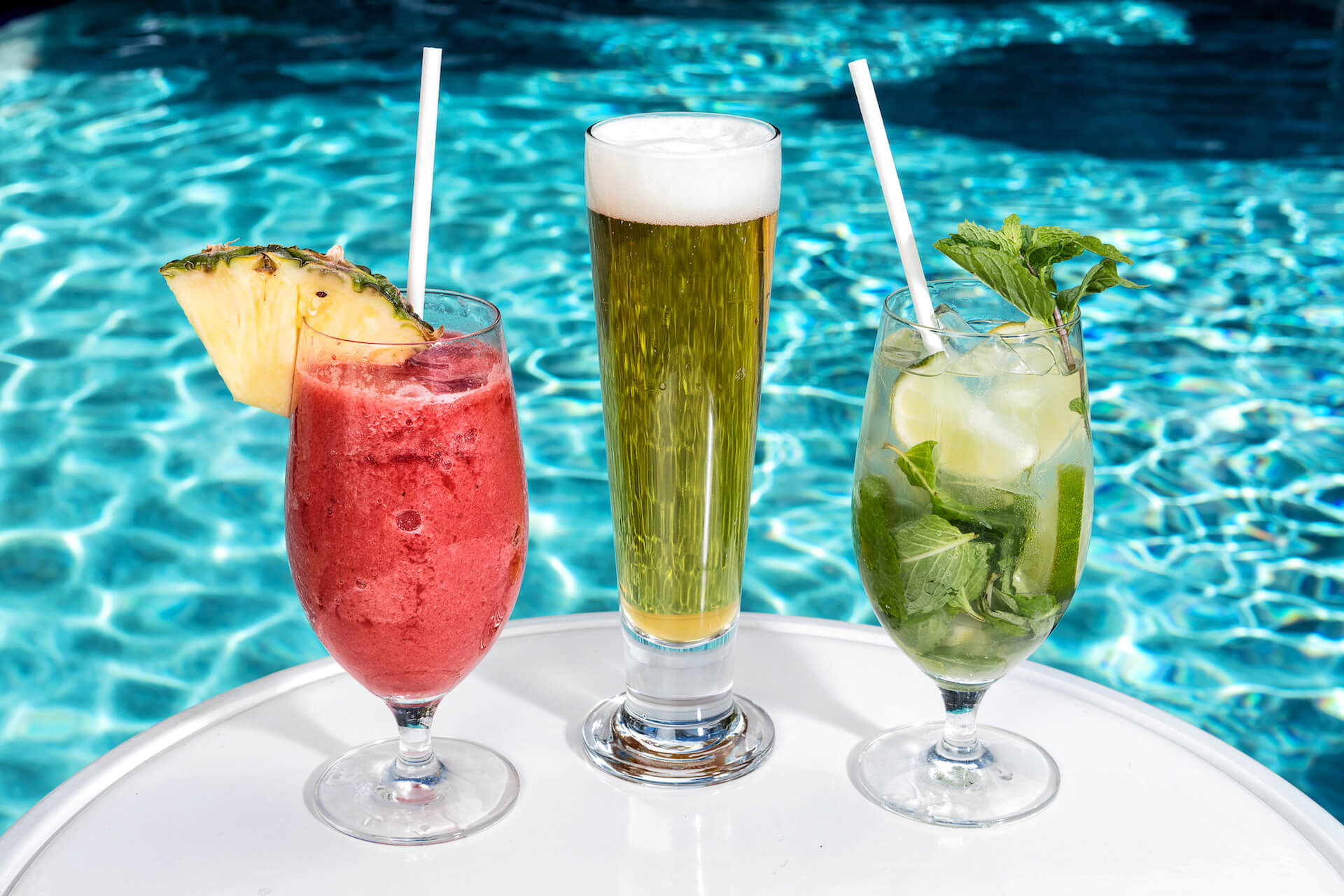 Tropical drinks on table with the crystal clear pool in the background